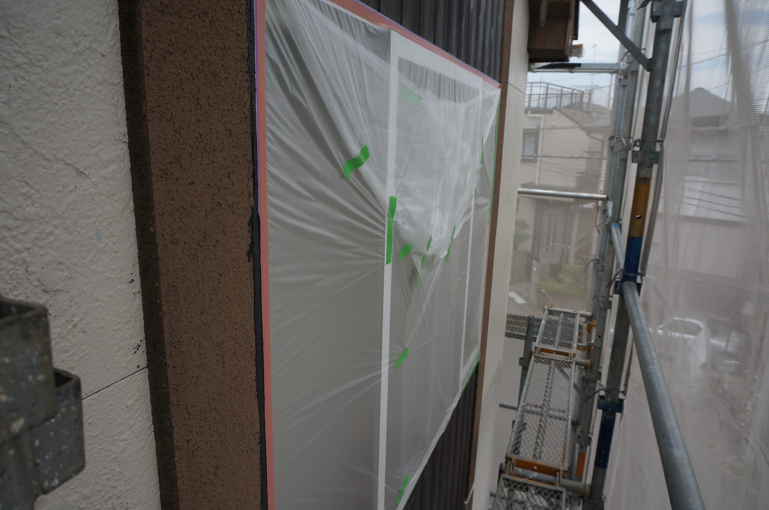 藤沢市の住宅で外壁をローラー塗装する職人